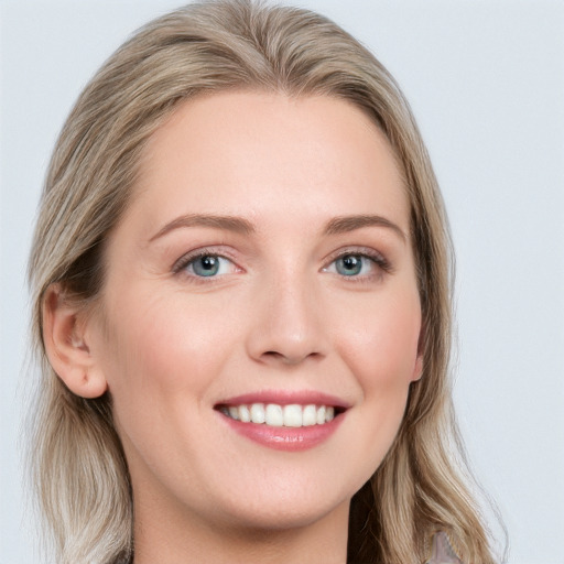 Joyful white young-adult female with long  brown hair and blue eyes