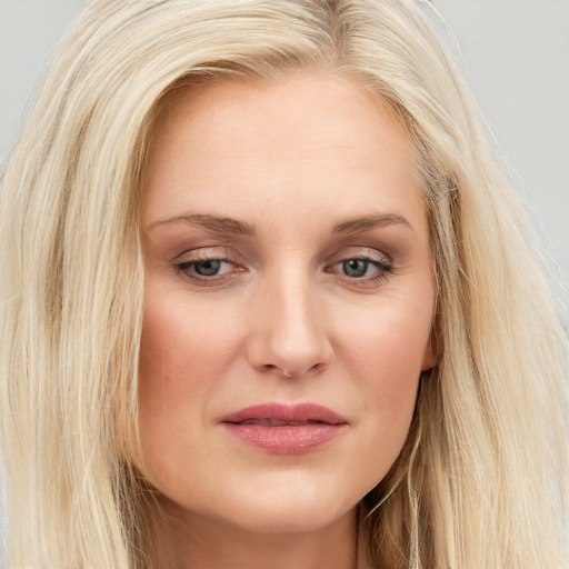 Joyful white young-adult female with long  blond hair and brown eyes