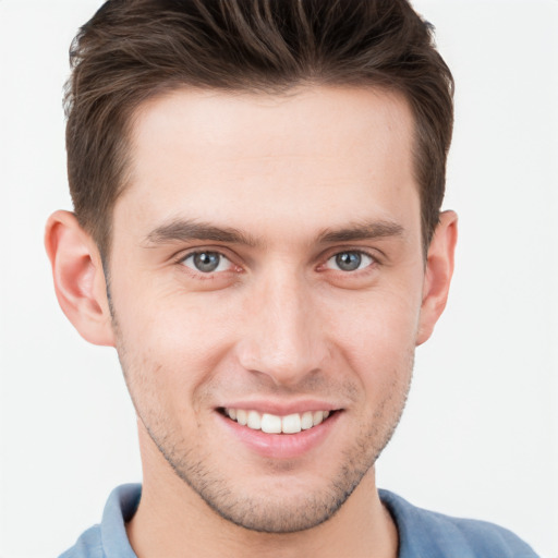 Joyful white young-adult male with short  brown hair and grey eyes