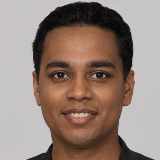 Joyful latino young-adult male with short  black hair and brown eyes