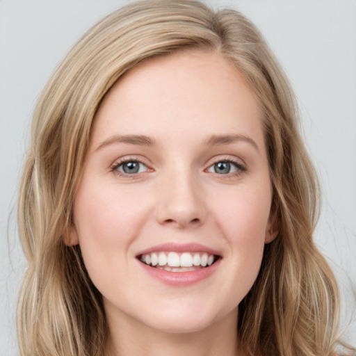 Joyful white young-adult female with long  brown hair and blue eyes