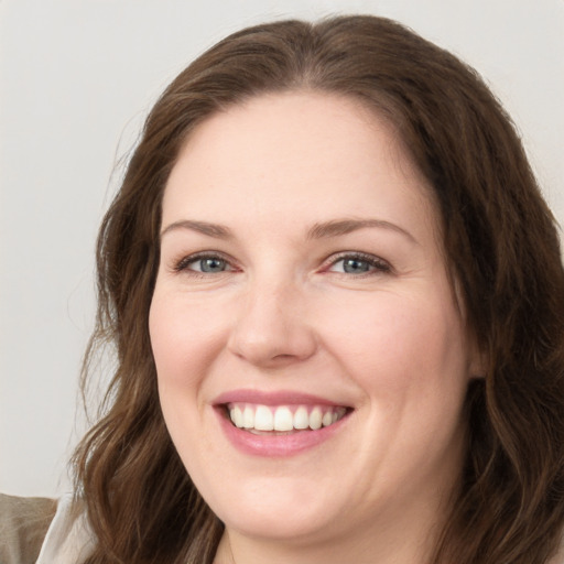 Joyful white young-adult female with long  brown hair and grey eyes