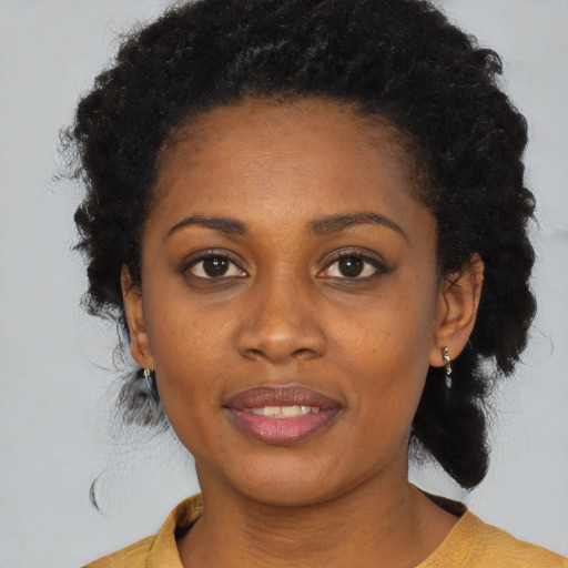 Joyful black young-adult female with medium  brown hair and brown eyes
