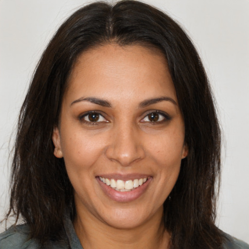 Joyful black young-adult female with long  brown hair and brown eyes