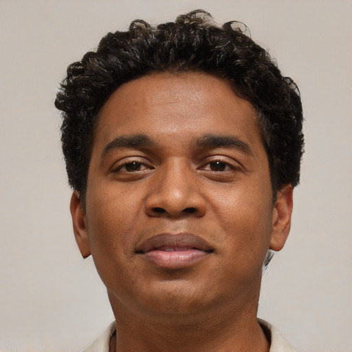 Joyful black young-adult male with short  black hair and brown eyes