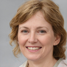 Joyful white adult female with medium  brown hair and blue eyes