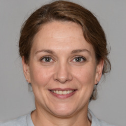 Joyful white adult female with medium  brown hair and grey eyes