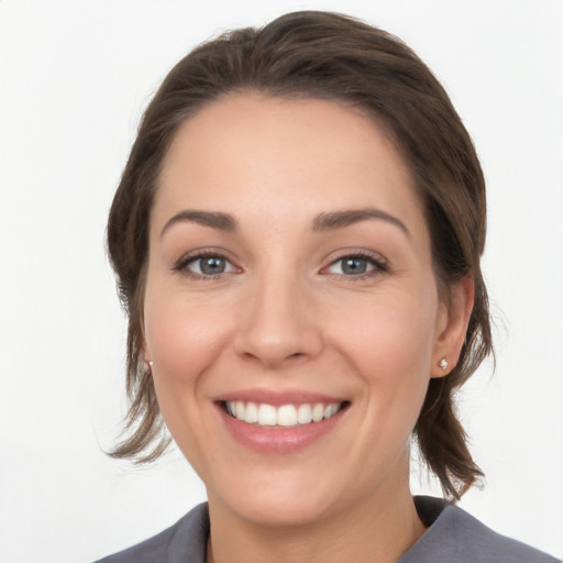 Joyful white young-adult female with medium  brown hair and grey eyes