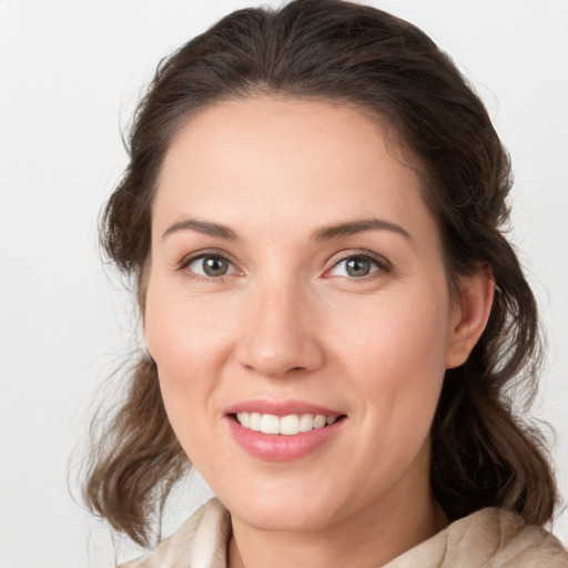 Joyful white young-adult female with medium  brown hair and grey eyes