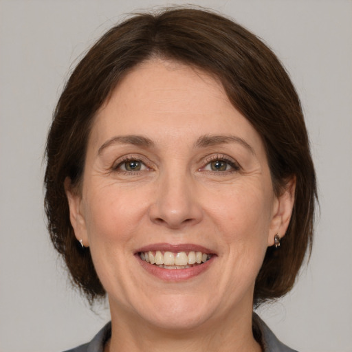 Joyful white adult female with medium  brown hair and brown eyes