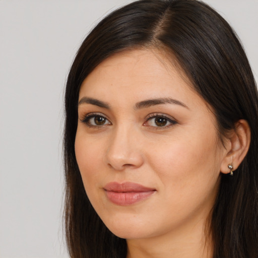 Joyful latino young-adult female with long  brown hair and brown eyes