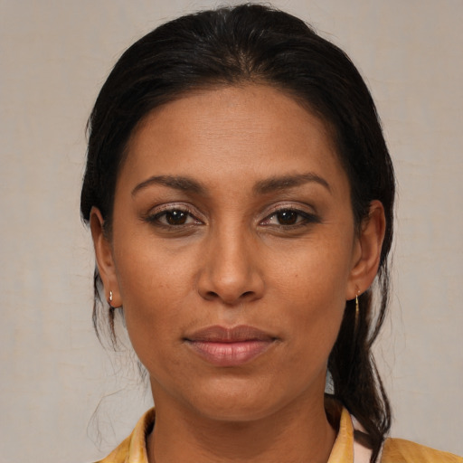 Joyful latino young-adult female with medium  brown hair and brown eyes