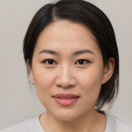 Joyful asian young-adult female with medium  brown hair and brown eyes