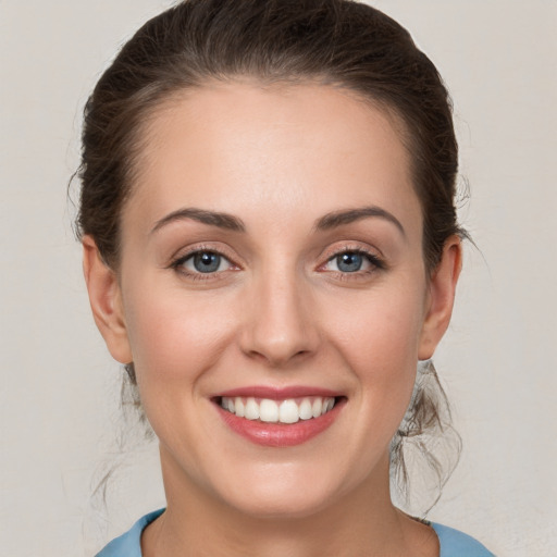 Joyful white young-adult female with medium  brown hair and grey eyes