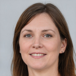 Joyful white adult female with long  brown hair and grey eyes