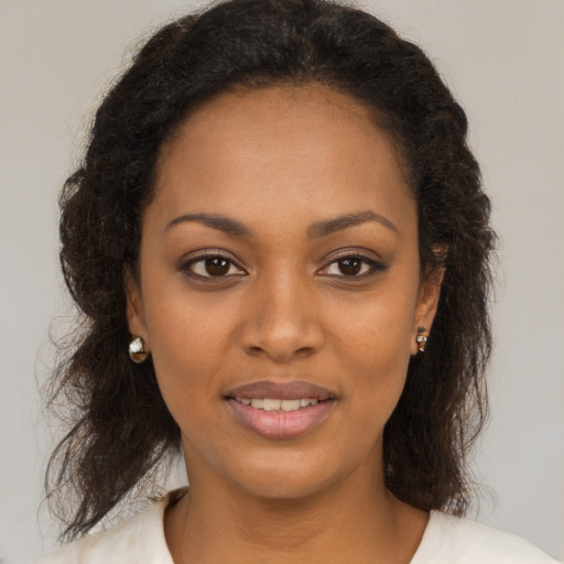 Joyful black young-adult female with long  brown hair and brown eyes