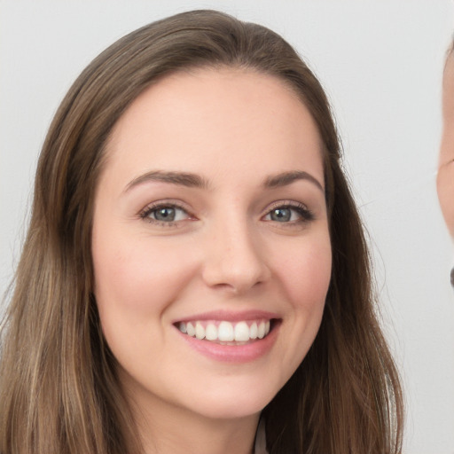 Joyful white young-adult female with long  brown hair and grey eyes