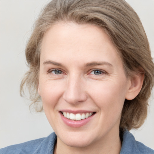 Joyful white young-adult female with medium  brown hair and blue eyes