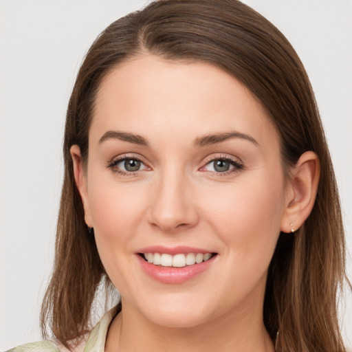 Joyful white young-adult female with long  brown hair and grey eyes