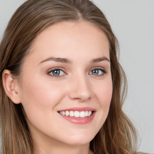 Joyful white young-adult female with long  brown hair and blue eyes