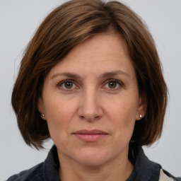 Joyful white adult female with medium  brown hair and grey eyes