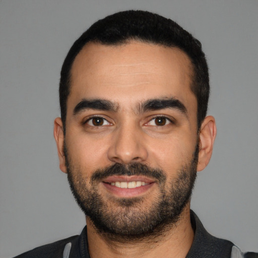 Joyful latino young-adult male with short  black hair and brown eyes