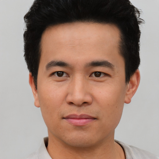 Joyful asian young-adult male with short  black hair and brown eyes