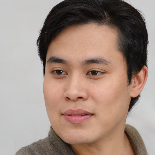Joyful asian young-adult male with short  brown hair and brown eyes