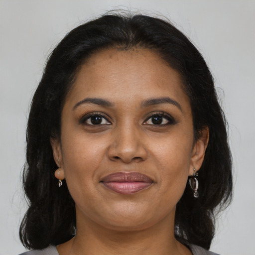 Joyful black adult female with long  brown hair and brown eyes