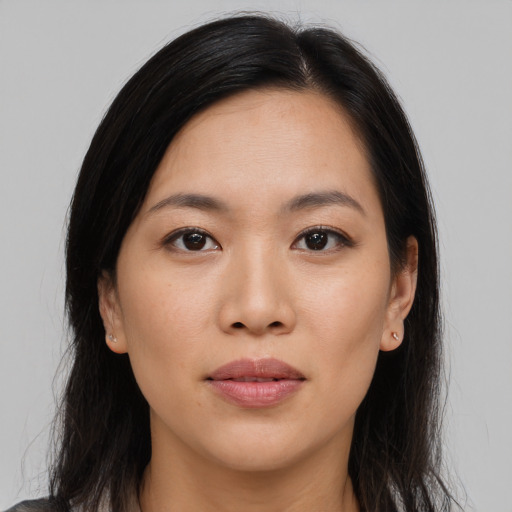 Joyful asian young-adult female with long  brown hair and brown eyes