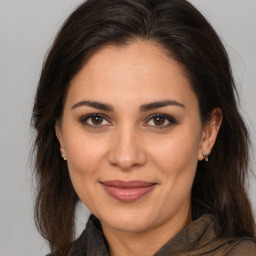 Joyful white adult female with medium  brown hair and brown eyes