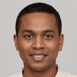 Joyful black young-adult male with short  black hair and brown eyes