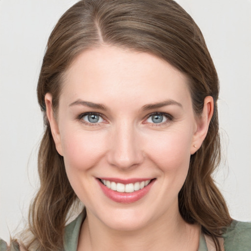 Joyful white young-adult female with medium  brown hair and grey eyes