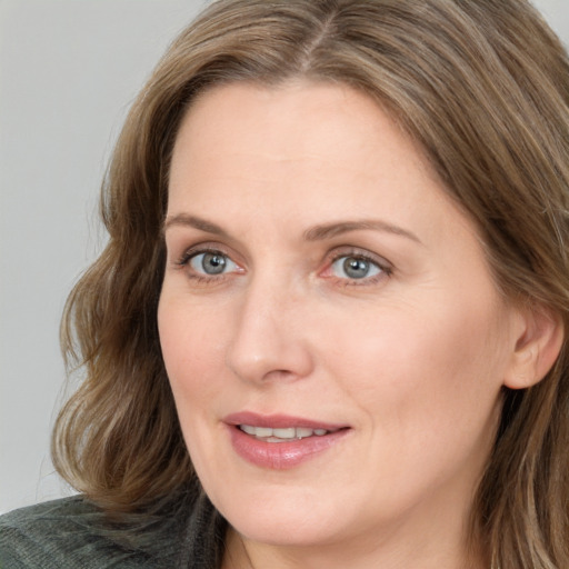 Joyful white young-adult female with medium  brown hair and blue eyes