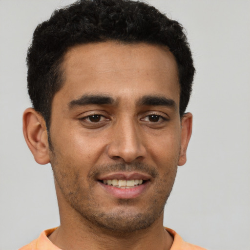 Joyful latino young-adult male with short  black hair and brown eyes