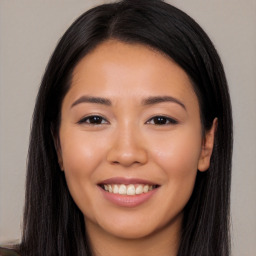 Joyful latino young-adult female with long  brown hair and brown eyes