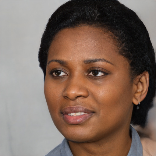 Joyful black young-adult female with short  black hair and brown eyes