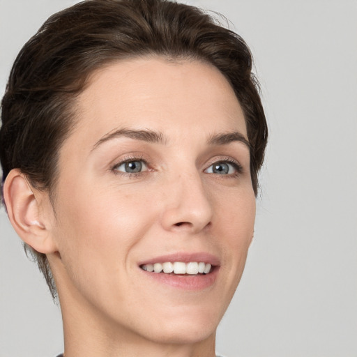 Joyful white young-adult female with short  brown hair and grey eyes