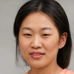 Joyful asian young-adult female with medium  brown hair and brown eyes