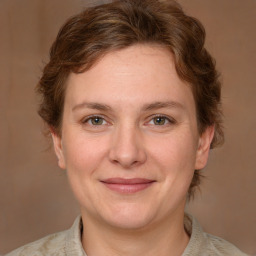 Joyful white adult female with medium  brown hair and green eyes