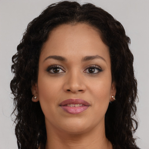Joyful black young-adult female with long  brown hair and brown eyes