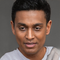 Joyful black young-adult male with short  black hair and brown eyes