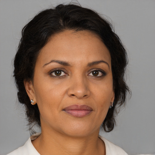 Joyful latino adult female with medium  brown hair and brown eyes