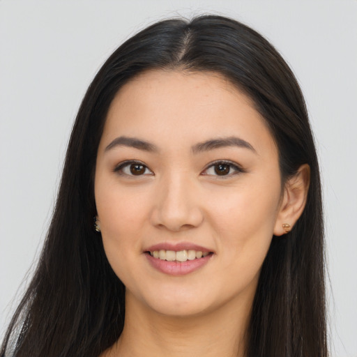 Joyful latino young-adult female with long  brown hair and brown eyes