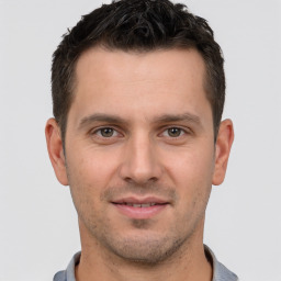 Joyful white young-adult male with short  brown hair and brown eyes