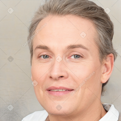 Joyful white adult female with short  brown hair and grey eyes