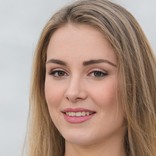 Joyful white young-adult female with long  brown hair and green eyes