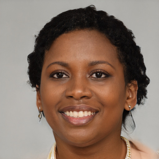 Joyful black young-adult female with short  brown hair and brown eyes
