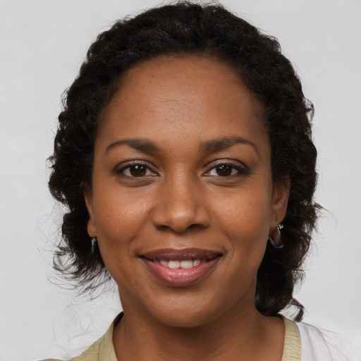 Joyful black young-adult female with medium  brown hair and brown eyes