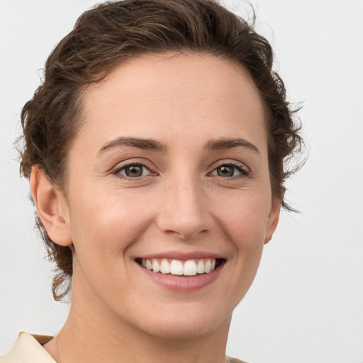 Joyful white young-adult female with short  brown hair and grey eyes